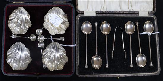 A set of six silver thistle terminal coffee spoons and tongs and a set of four Victorian silver shell salts and spoons, both cased